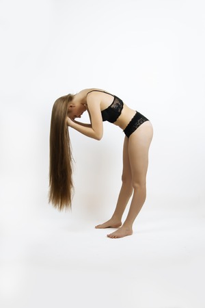 beautiful young woman show her luxurious shiny long hair, natural color, side view, full body, Underwearの写真素材