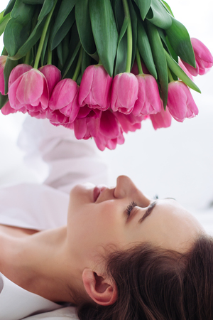 Beautiful woman face with pink tulips.の写真素材