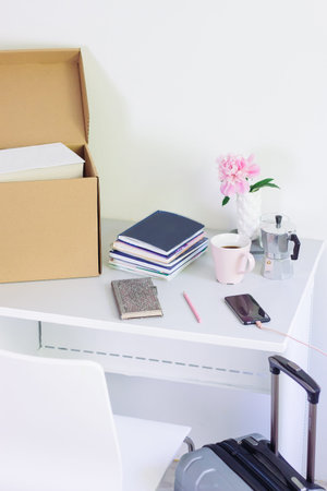 table with stationery, unpacking box with books. girl Back to college. Coffee, flowers, notebook