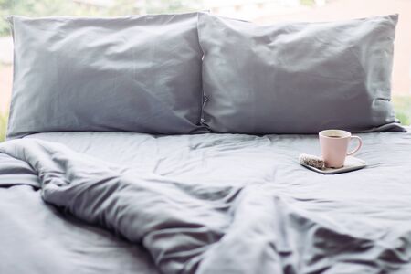 grey bed sunlight sunday. pillow blanket. cup backgroundの写真素材