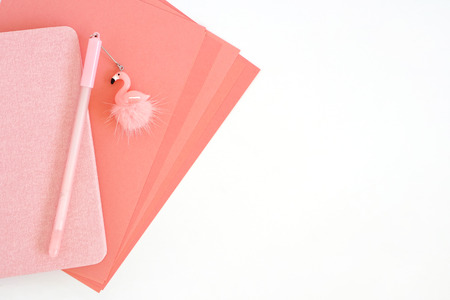 Pink sheets of paper, notepad and pen with flamingo on white backgroundの写真素材