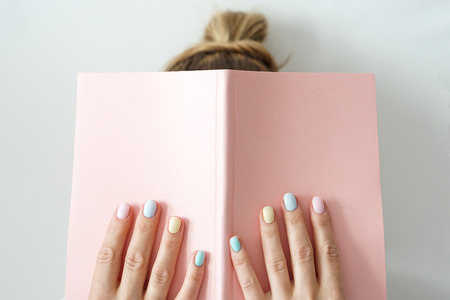 Stylish trendy color female manicure . Women s hands keep pink note padの写真素材