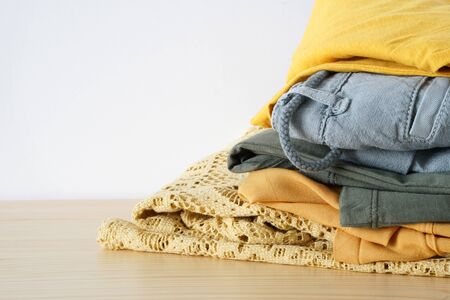 Stack of clothes on wooden table and white background isolationの写真素材