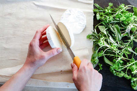Camembert cheese pita bread rosemary parsley basil sage, woman s hands. Food recipesの写真素材
