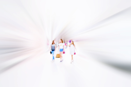 Women walking fast in shopping mall with bagsの写真素材
