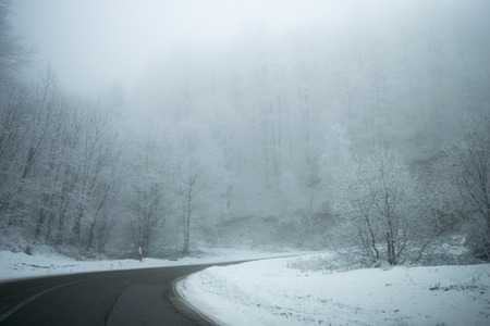 Road in the fog. Mysterious Way. Snowy mountain road. Risk of ice.の写真素材