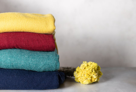 stack of woolen colorful sweaters on a gray background