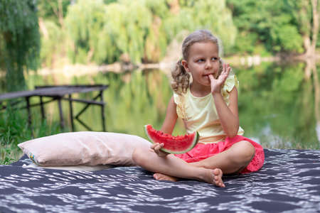 curly girl eating juicy watermelonの写真素材