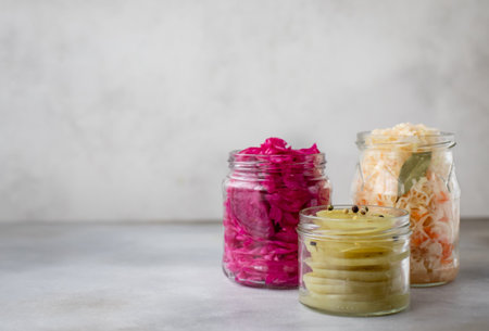 various fermented vegetables in jars. Cabbage, green tomatoes. gray background, copy space,...
