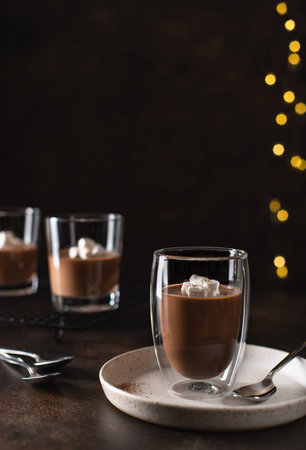 dessert panna cotta in a double wall glass, decorated with marshmallows. blurred christmas...