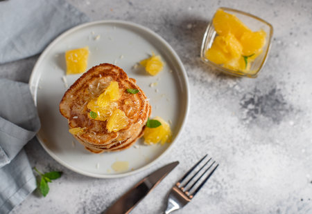 Tasty pancakes served with orange and mint. gray background, top view, horizontal image, copy spaceの写真素材