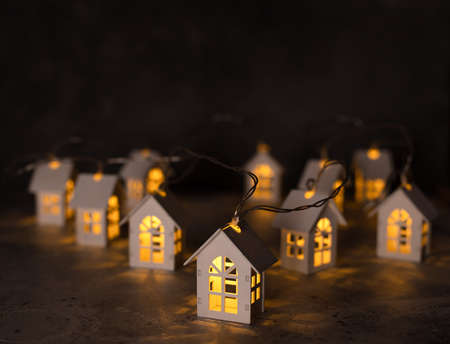 Christmas lights, garland in the form of wooden houses. Christmas and New Year holiday background.の写真素材