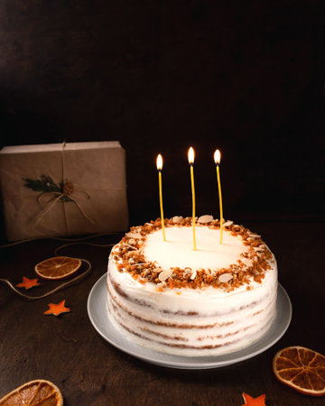 Christmas homemade cake on a dark background, burning candles. close-up