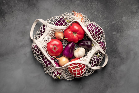 reusable mesh bag for shopping, with fresh vegetables.