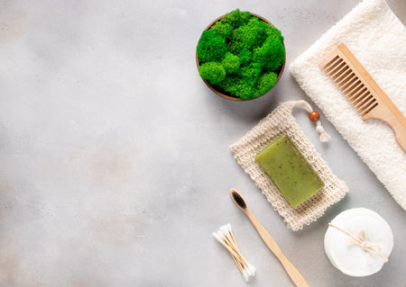 Eco-friendly bath accessories and stabilized moss in pot on gray background.