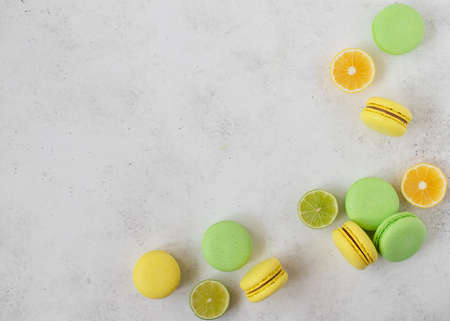 Macarons and slices of lemon, lime. white concrete background. copy spaceの写真素材
