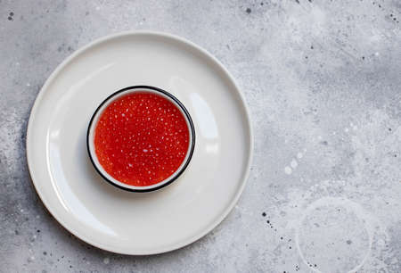 red caviar in a white bowl on a light background. seafood meal. top view. copy spaceの写真素材