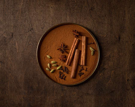 Different winter spices, cinnamon, cardamom, star anise, cloves. Rustic wood background, top view.の写真素材