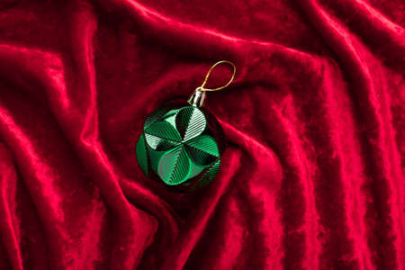 green christmas decoration on red velvet waves background. Trendy colors of 2021の写真素材