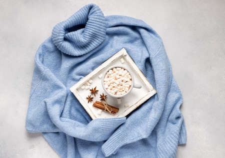 cup with hot chocolate or coffee with marshmallows and spices on wooden trayの写真素材