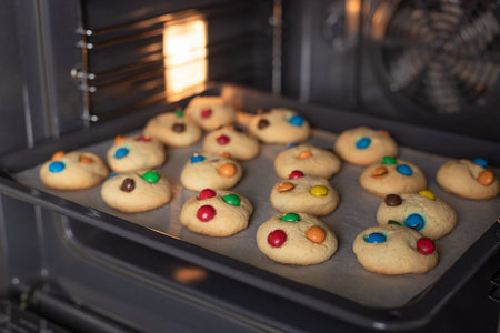 Baking tray with fresh cookies in oven.