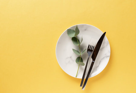 ceramic marble plate with cutlery. Illuminating Yellow and Ultimate Gray
