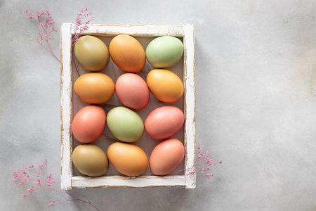 Pastel Easter eggs in white wooden box. natural egg dye