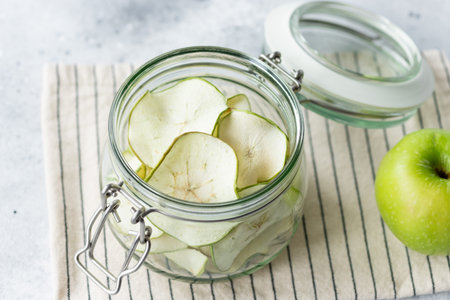 full glass jar of dehydrated apple chips.