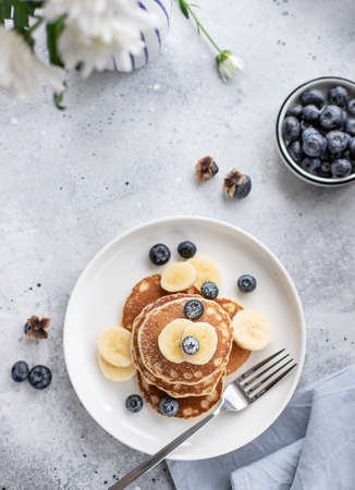 pancakes with fresh blueberries, banana on gray backgroundの写真素材