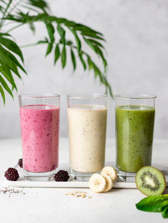 Three various of purple, yellow, green smoothie drinks with ingredients. healthy detox breakfast....