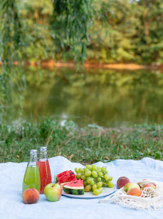 summer picnic by lake at sunsetの写真素材