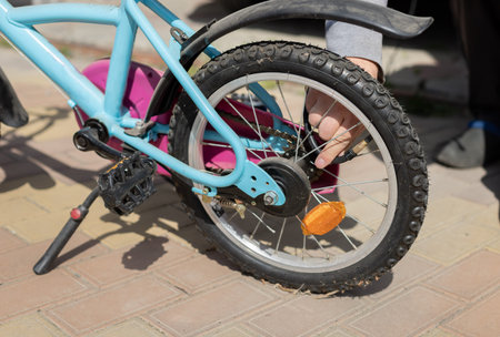 male hands pump up the wheel on a childrens bike. Pumping air into a bicycle wheel. close-up
