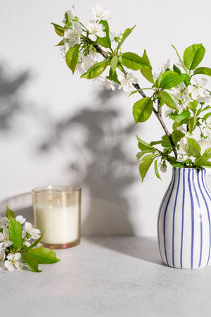 scented candle and cherry tree blossoms on table