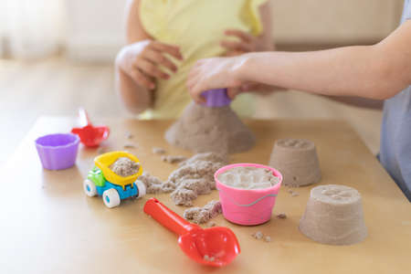 Kinetic sand of natural color with toys on tableの写真素材