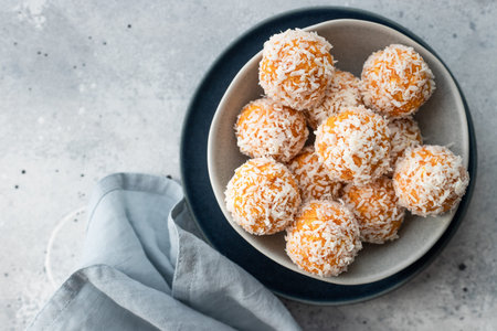 apricot coconut bliss balls in blue bowlの写真素材