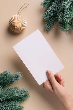 Greeting card mockup with vertical blank paper card in female handの写真素材