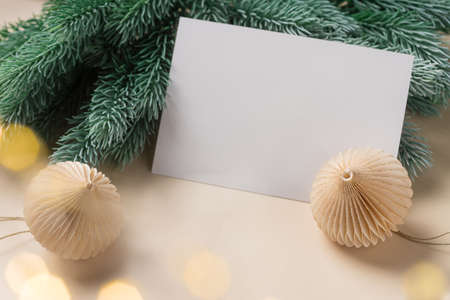 Paper blank, Christmas decorations, fir branches on beige backgroundの写真素材