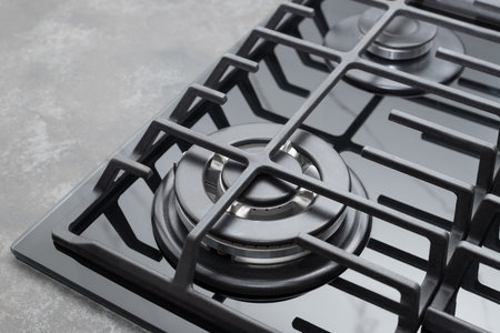 Black gas stove on dark countertop