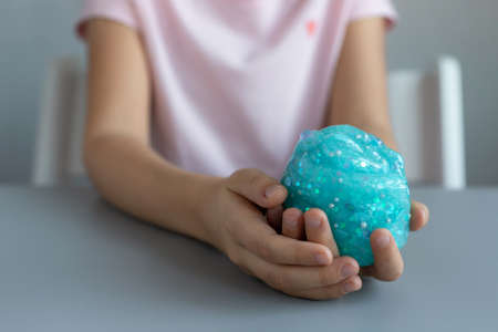 preschooler girl holding blue glitter slime. fun sensory toys for kidsの写真素材