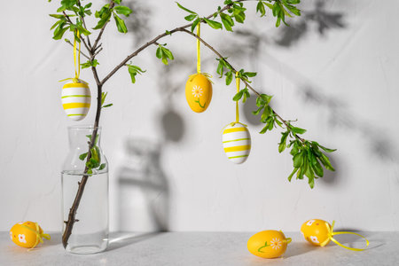 Easter tree with colorful Easter eggs against gray wall. Modern minimalistic Easter decor. long shadowsの写真素材