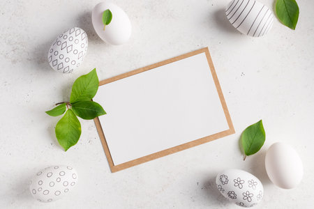 flat lay composition with blank paper card and easter eggs with pattern on white background. Happy...