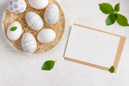 Easter composition with blank paper card and easter eggs with pattern on white background. Happy...