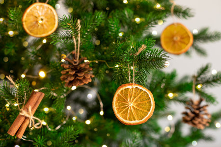 Christmas tree with natural decoration. Dried orange slices, fir cones and cinnamon sticks hanging on Christmas tree. closeupの写真素材