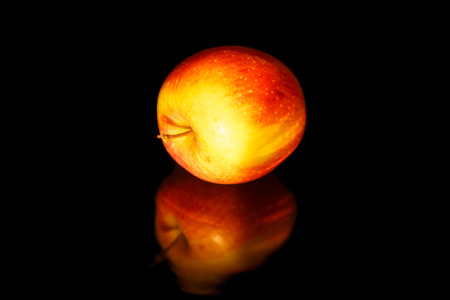 Apples on black wavy mirror.の写真素材