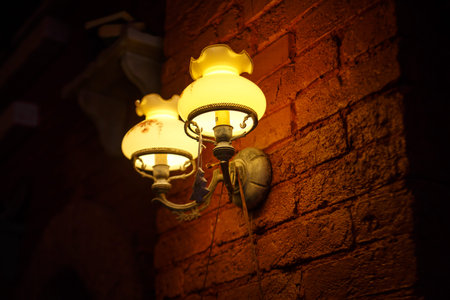 The lights at brown brick wall, around all is dark.