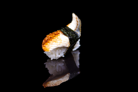 Sushi with eel on a black mirror with reflection.の写真素材