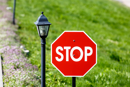 Stop sign is a red octagon on background of grass and riversの写真素材