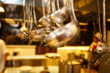 Kitchenware hanging in the kitchen of the restaurant.の写真素材