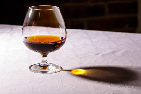 The glare from the glass of French brandy reflected on white tablecloths.