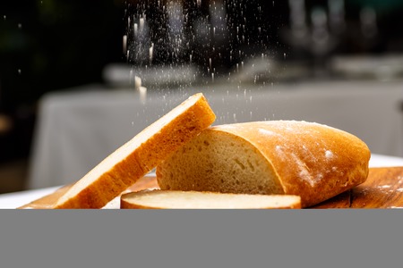 And sliced bread in one piece and a bit of butter lying on a wooden Board.の写真素材